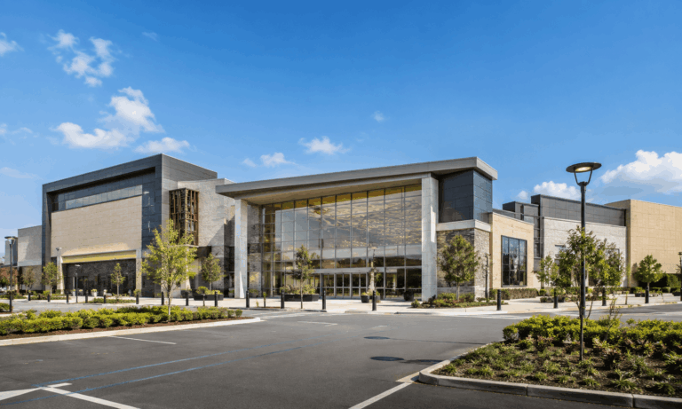 Modern shopping mall entrance with professionally maintained landscaping